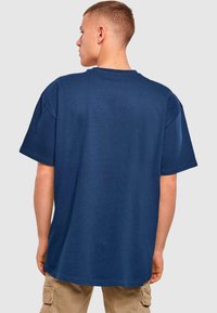 Mørkeblå bomulds T-shirt med en afslappet pasform, korte ærmer og rund halsudskæring, der har en glat tekstur og et minimalistisk design.