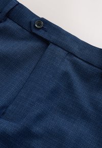 Dunkelblaue Hose aus strukturiertem Stoff, mit einem einzelnen schwarzen Knopf am Bund und flachem Vorderdesign.