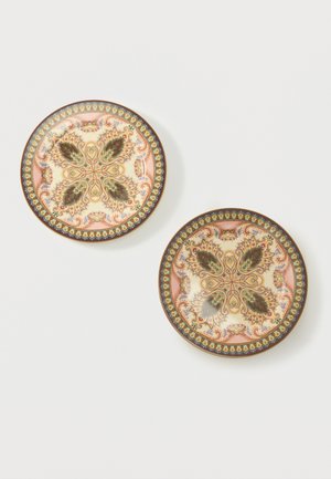 Dos platos redondos decorativos con patrones simétricos intrincados de flores y hojas en verde, rosa, dorado y marrón sobre fondo crema.