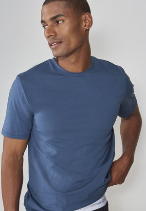 Blue cotton t-shirt with a round neckline, short sleeves, and a fitted style. Features subtle stitching details and a visible waistband label.