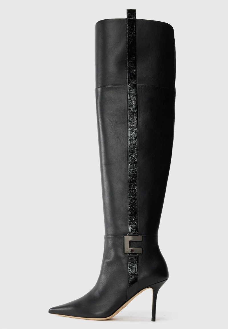 Black knee-high leather stiletto boot with pointed toe, vertical glossy stripe, and front metal buckle detail on plain light background.