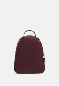 Sac à dos compact couleur bordeaux avec une poignée supérieure, des détails de fermeture éclair dorée et un petit logo "Anna Field" au centre avant.