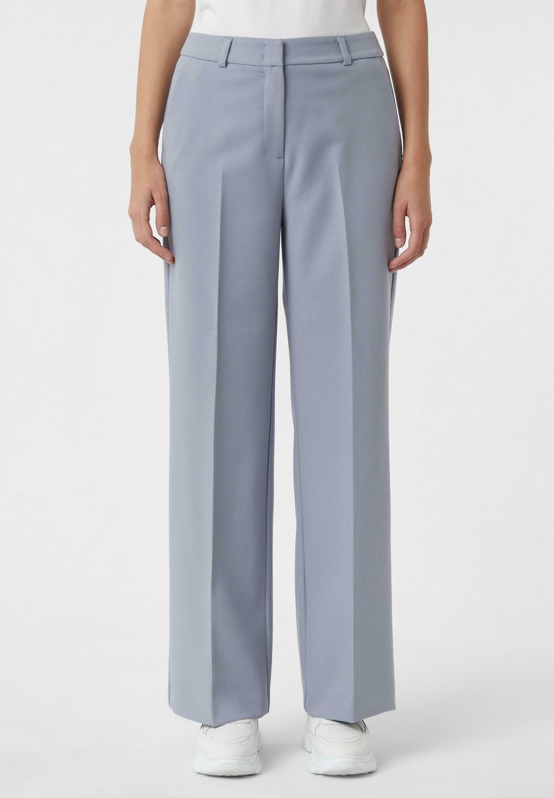 Jasnoszare szerokie spodnie wykonane z gładkiego materiału, o dopasowanym kroju, z przodu z krokami i płaskim paskiem w talii.