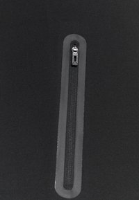 Czarna odzież z zamkiem błyskawicznym, charakteryzująca się gładką, miękką teksturą oraz ukrytym zamkiem, uzupełniona nowoczesnym, minimalistycznym wzornictwem.