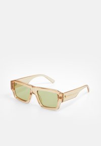 Translucent beige sunglasses with square frames, green tinted lenses, and clear arms. Notable texture on frames; subtle brand detailing on arms.