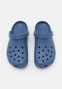 Tamancos azuis Crocs com um design perfurado, feitos de material de espuma durável. Possuem uma alça traseira ajustável e solas texturizadas para melhor aderência.