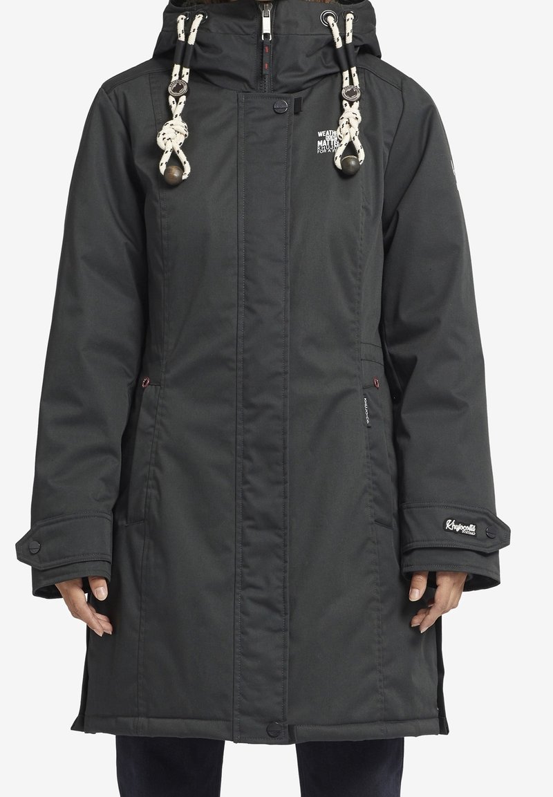 Manteau d'hiver long noir avec capuche, cordons de serrage blancs, fermeture éclair à l'avant, poignets boutonnés et poches avant, porté par une personne.