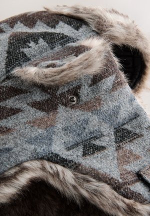 Căciulă din lână cu modele geometrice în nuanțe de gri, maro și negru; are o căptușeală de blană și un detaliu cu nasture argintiu lângă bor.