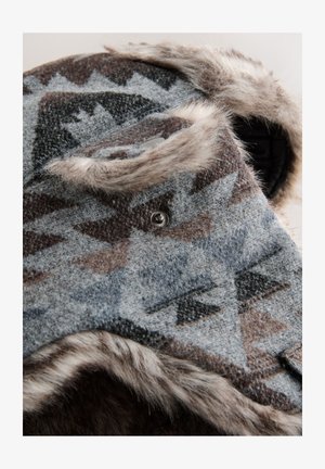Căciulă din lână cu modele geometrice în nuanțe de gri, maro și negru; are o căptușeală de blană și un detaliu cu nasture argintiu lângă bor.