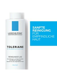White bottle of Toleriane cleansing fluid with a round cap; features a blue square label and black text; designed for sensitive skin.
