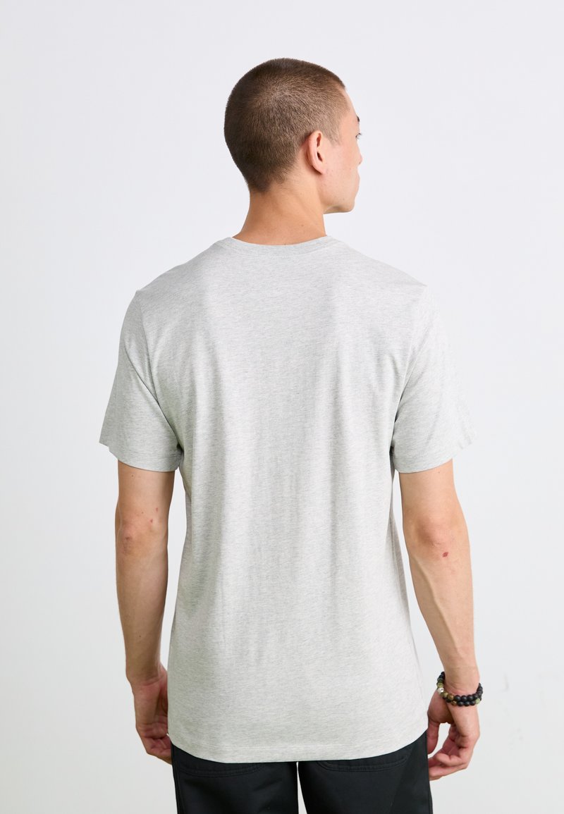 Szary t-shirt wykonany z bawełny, z okrągłym dekoltem i krótkimi rękawami. Widok z tyłu ukazuje luźny krój z minimalnym wykończeniem.