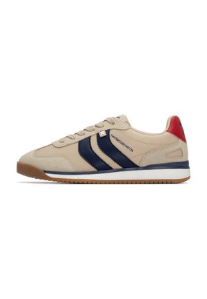 Zapatilla beige con rayas marinas, suela de goma, materiales de piel y ante, puntera redonda y acento rojo en el talón. Diseño simple de cordones.