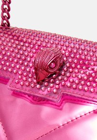Różowa syntetyczna torebka z teksturowaną, kolczastą powierzchnią. Posiada dekoracyjny różowy element z metaloplastyki w kształcie pióra. Łańcuszkowy pasek na ramię.