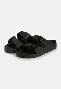 Dark green plastic sandals with two wide straps and adjustable black buckles. Contoured footbed and textured sole for grip.