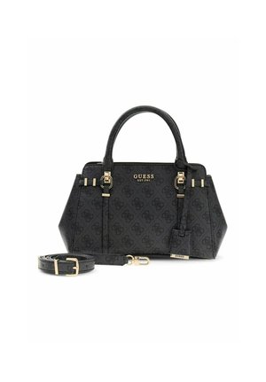 Bolso negro de Guess con herrajes dorados, patrón de monograma, doble asa y correa desmontable enrollada a su lado sobre fondo blanco.