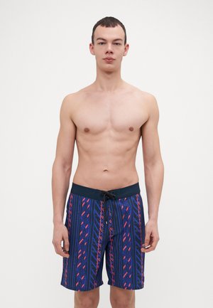 Shorts de bain bleus avec un motif comportant des accents rouges et violets. Fabriqués en matériau léger, ils possèdent une taille élastique et un cordon de serrage.