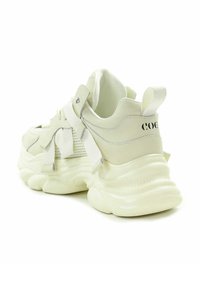 Białe sneakersy z siateczkową cholewką, teksturowaną gumową podeszwą i masywnym designem. Zawierają ozdobne sznurówki oraz logo na pięcie.