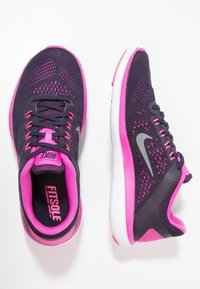 Scarpe sportive viola e rosa con tomaia in rete, lacci e logo. Presentano una suola ammortizzata e dettagli testurizzati sui lati.