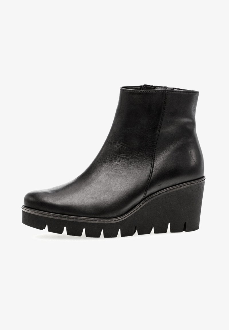 Bottine en cuir noir avec talon compensé et semelle épaisse rainurée, fermeture éclair latérale, dessus lisse texturé.