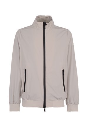 Giacca beige chiaro con cerniera, collo alto, zip frontale nera, tasche laterali con zip, polsini ed orlo elasticizzati.