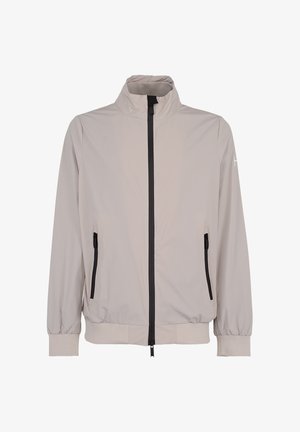 Jasna beżowa kurtka zapinana na zamek z kołnierzem stojącym, czarnym zamkiem z przodu, zamykanymi na zamek bocznymi kieszeniami, elastycznymi mankietami i dołem.