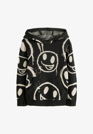 Hoodie noir avec un motif de visage souriant en crème, en tissu tricoté, avec des poignets côtelés et une poche frontale. Texturé avec un design à capuche.