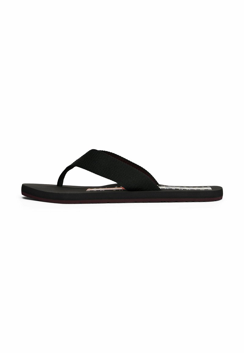 Infradito neri con una fascia testurizzata e una suola piatta in gomma. Presentano un design minimalista senza loghi o motivi visibili.