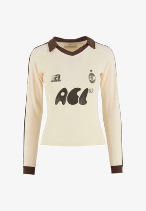 Jersey crème à manches longues avec col et poignets marron, présentant un logo graphique noir et un ourlet arrondi. Fabriqué à partir d'un tissu doux et texturé.