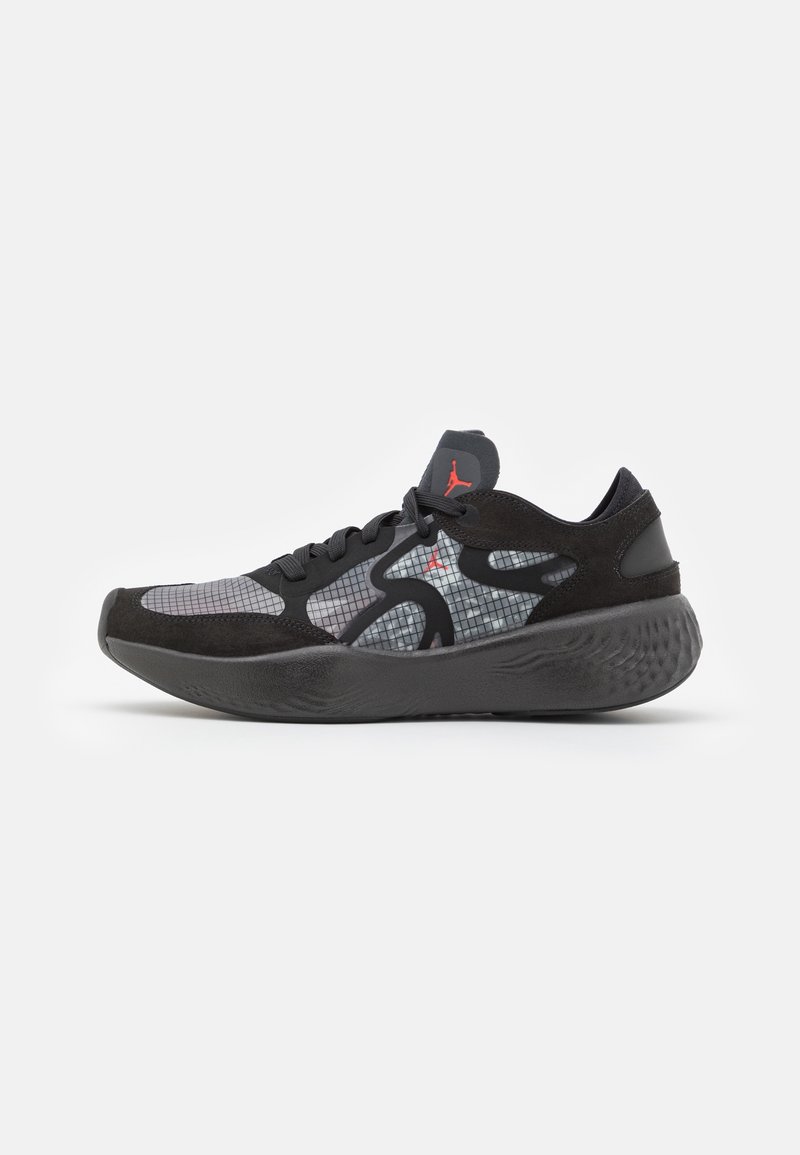 Baskets de sport noires et grises avec motif en grille, semelle épaisse, lacets noirs et logo rouge sur le côté et la languette, vues de côté.