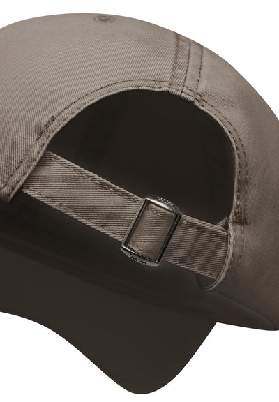 Taupe baseballcap med justerbar stofrem og sølvfarvet metalspænde bagpå, vist mod en mørk baggrund.
