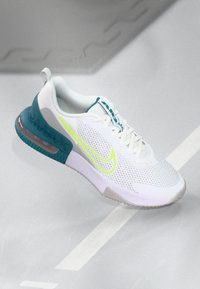 White mesh sneaker with teal accents, prominent air cushioning, and neon yellow branding. Features a textured sole for grip and support.