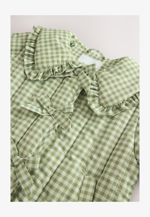 Siūtas žalias gingham švarkas su raukšlėta apykakle ir kaspinų akcentais. Pagamintas iš lengvo audinio su languotu raštu.