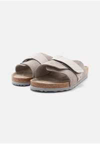 Gray suede sandals with wide straps, cork footbed, and gray rubber outsole. Features hook-and-loop closure for adjustable fit.