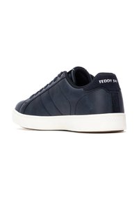 Basket en cuir bleu marine avec semelle en caoutchouc blanche, accents texturés et bandes latérales discrètes. Logo "TEDDY SMITH" sur le talon.