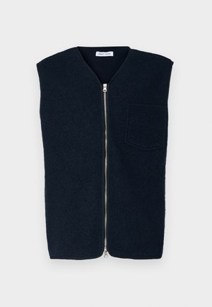Marineblå uldvest med høj hals, lynlåslukning foran og en enkelt bryster lomme. Glat tekstur og minimalistisk design.