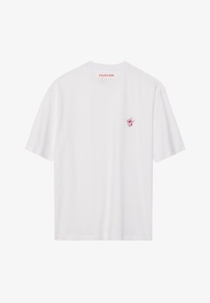 T-shirt bianco a maniche corte in cotone, con una piccola grafica rossa sul lato sinistro del petto. Collo tondo, vestibilità rilassata.