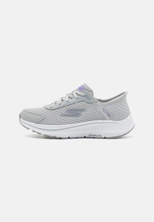 Light gray athletic shoes featuring a mesh upper, textured design, and a white sole. Reflective accents and laces included.