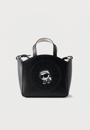 Bolso de cuero negro con asas cortas, con un logotipo circular perforado y un personaje de dibujos animados con gafas de sol en el frente.