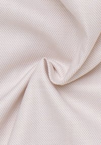 Tessuto tessuto in rosa pallido con un motivo geometrico testurizzato. Texture morbida e liscia con un delicato lucido e una sensazione di leggerezza.