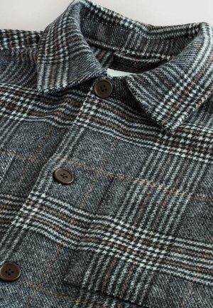 Grau und schwarze karierte Jacke aus strukturiertem Stoff, mit kragen, zwei braunen Knopfverschlüssen und einer Brusttasche.