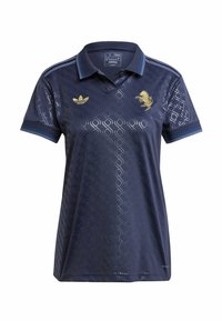 Tummansininen polo-paita, jossa on teksturoitu timanttikuvio, kultalangalla brodeerattu logo ja kolme raitaa harteilla.