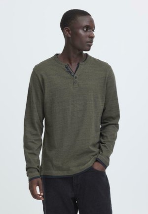 Dugih rukava khaki henley majica od teksturiranog materijala s tri dugmeta na izrezu i kontrastnim tamnim manžetama.