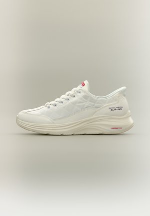 Baskets blanches Skechers Slip-Ins avec motif matelassé, laçage à l’avant et semelle amortissante Contour Foam sur fond neutre.