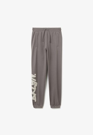 Graue sportliche Jogginghosen aus weichem Stoff mit einem Tunnelzugbund, zwei Seitentaschen und einem großen weißen Logo am linken Bein.