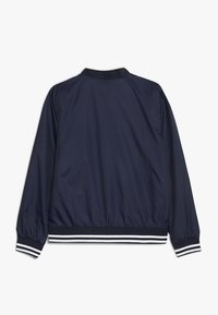 Giacca bomber nautica realizzata in nylon liscio, con colletto e polsini a coste, e strisce bianche all'orlo e ai polsini.