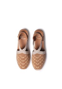 Bruna mocka slingback-skor med en textil ankle strap, utskuret mönster och en texturerad sula. Accentuerade med en beige vävd kant.