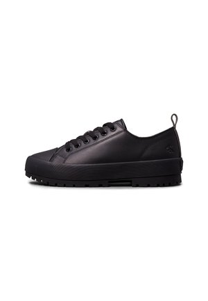 Schwarzer flacher Ledersneaker mit dicker Gummisohle und schwarzen Schnürsenkeln, mit kleinem Calvin Klein-Logo in der Nähe der Ferse.