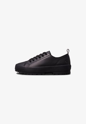 Baskets basses en cuir noir avec semelle épaisse en caoutchouc et lacets noirs, avec un petit logo Calvin Klein près du talon.