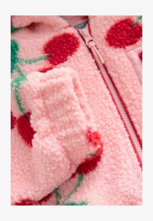Jachetă din fleece roz, cu fermoar, având modele cu cireșe roșii și tulpini verzi. Textura este moale și pufoasă, cu un detaliu de fermoar care se poate închide.