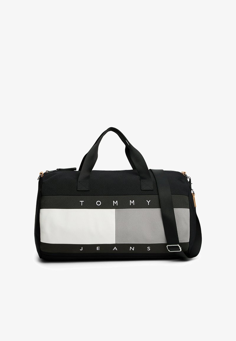 Czarna i szara torba sportowa z kontrastującymi sekcjami, wyraźnym napisem "TOMMY JEANS", podwójnymi uchwytami i regulowanym paskiem na ramię.